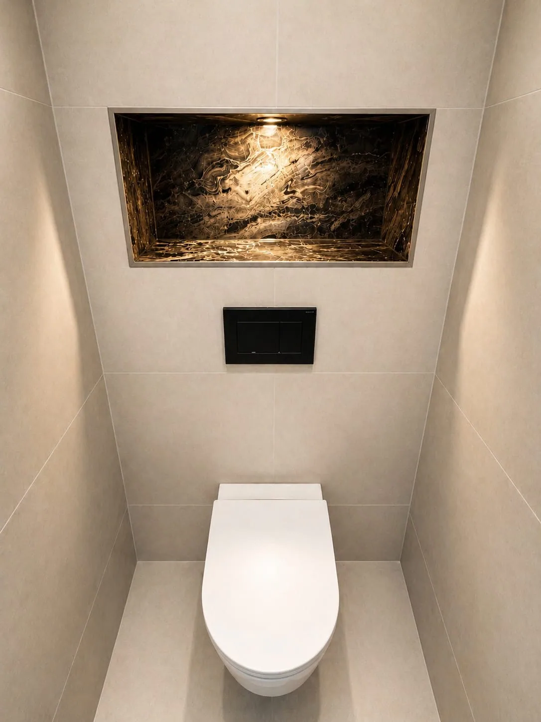 Strakke wc met hangtoilet, zwarte drukplaat en een verlichte nis met natuursteen erboven
