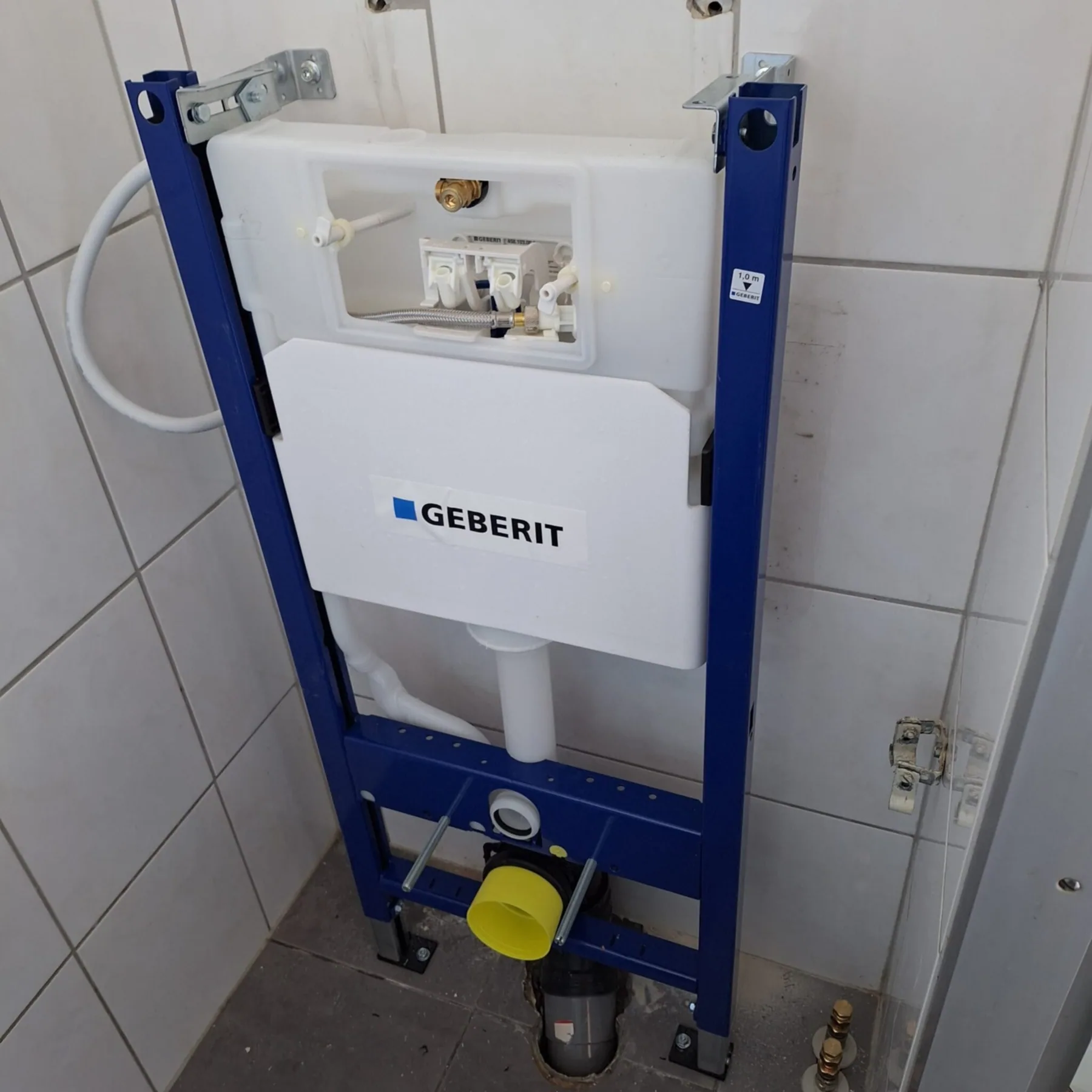 Geplaatst inbouwreservoir met frame voor een hangtoilet tegen een betegelde wand