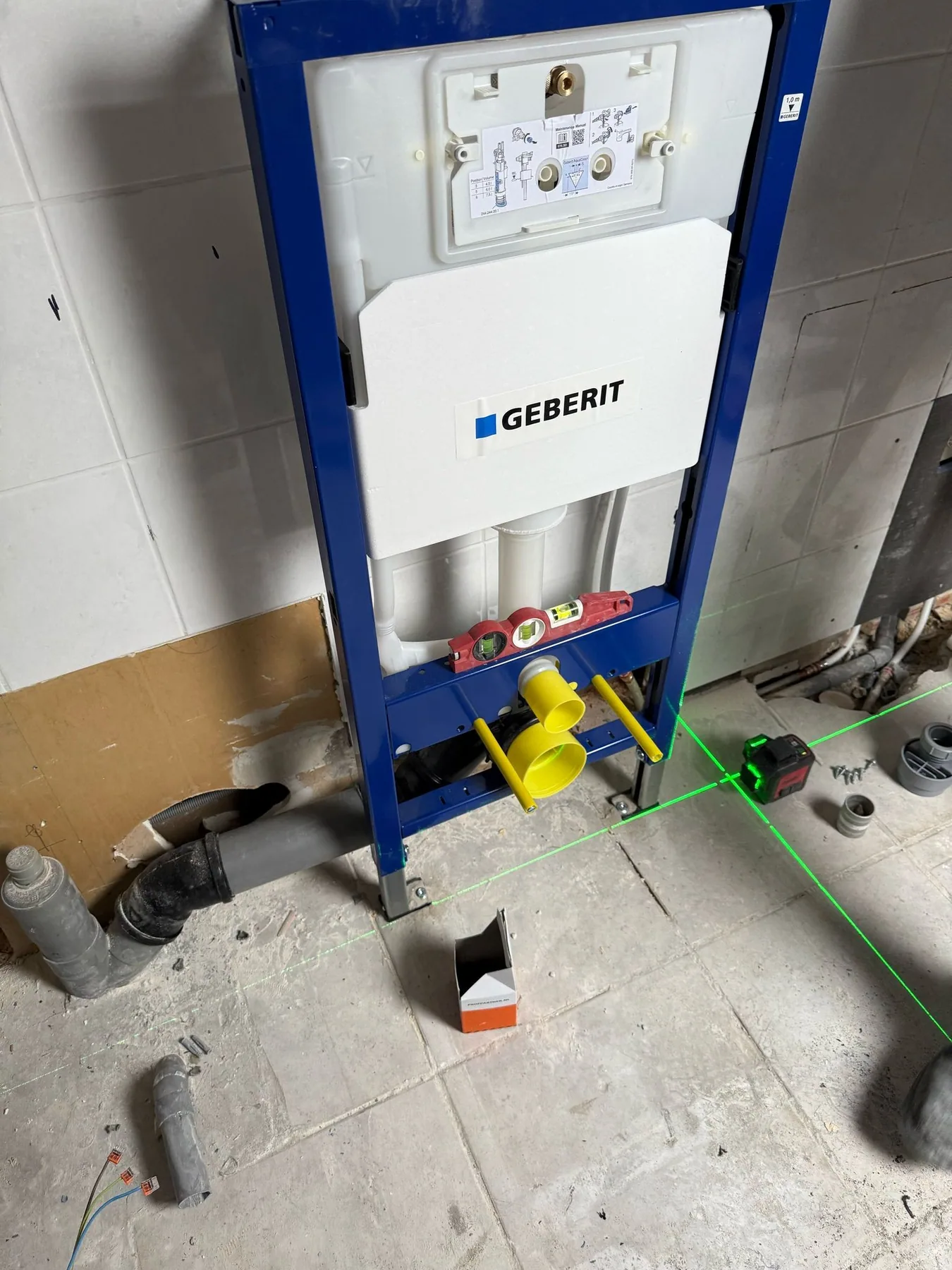 Inbouwreservoir in een montageframe voor een hangtoilet, uitgelijnd met een laserlijn, nog zonder voorzetwand