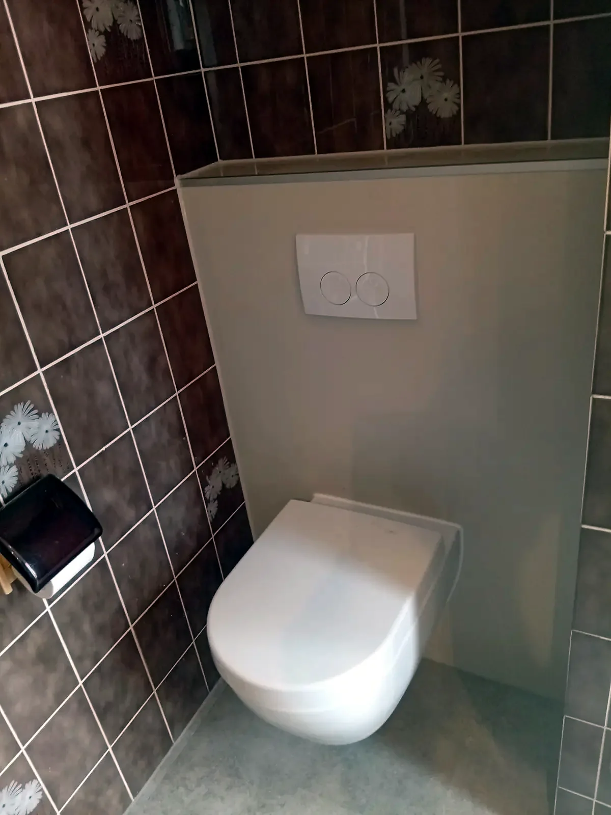 Na: dezelfde hoek met een hangtoilet op een nieuwe lichte voorzetwand, de bruine tegels errond bleven